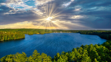 Aerial panoramic landscape with a small town at a dramatic colorful sunset with blue sky and gold clouds