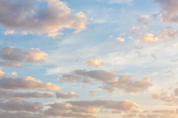 Beautiful fluffy clouds painted in pastel colors at sunrise. Multicolor background or wallpaper