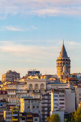 Fototapeta na wymiar Istanbul, Turkey, April 29, 2022 - Cityscape with Galata Tower in Istanbul, Turkey at golden hour painted with sun. Tourism or architecture history concept