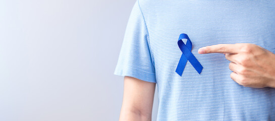 March Colorectal Cancer Awareness month, Woman holding dark Blue Ribbon for supporting people...