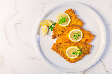 Breaded fish, baked and served with lemon. Common dab, edible flatfisch