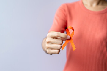 Fototapeta premium Orange Ribbon for Leukemia, Kidney cancer day, world Multiple Sclerosis, CRPS, Self Injury Awareness month. Healthcare and word cancer day concept