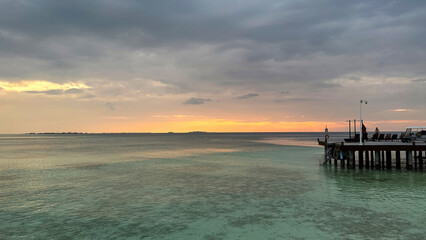 Beautiful Tropical sunset landscape in Maldives island Baa , with infinity Indian ocean sea water view and cloudy skies , perfect relaxing Honeymoon travel destination 