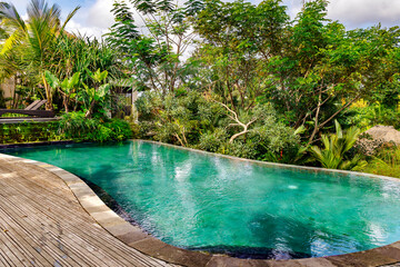 Small swimming pool with clear turquoise water among tropical plants in Ubud, Bali, Indonesia. Scenic place to vacation relax.