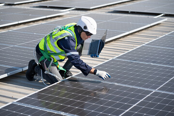 Caucasian engineer man use electric screwdriver and computer notebook working with solar panel on...