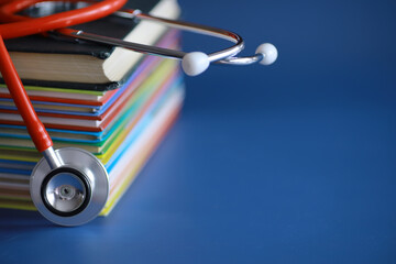 stethoscope on stack of medical guide book for doctor learning treatment at hospital.