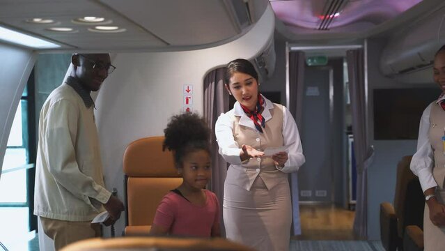 Passengers boarding the plane with boarding pass checked by flight attendants while welcoming at plane entrance. Concept of airline, business, transportation and multiracial stewardess on aircraft.
