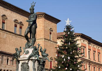 Fototapeta na wymiar The Big Christmas Tree and The Fountain of Neptune in the main square of Bologna. Italy.