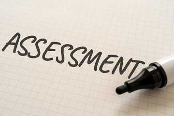 ASSESSMENTと書かれた紙とマーカー