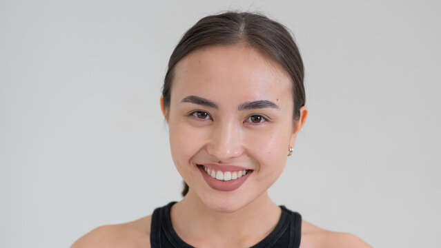 Portrait of a smiling Asian woman on a white background.