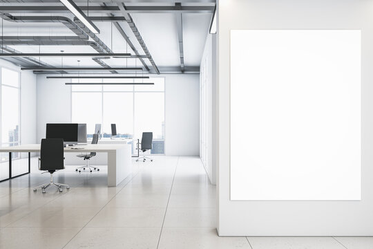Front view on blank white poster on light wall background in spacious coworking office with monochrome interior design, light glossy floor, loft ceiling lamps and big window. 3D rendering, mock up