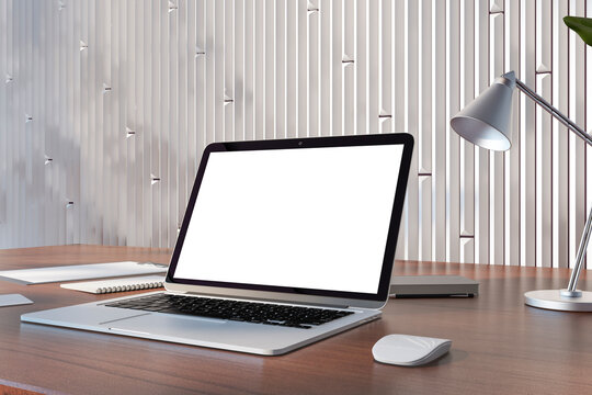 Perspective view on blank white modern laptop screen with space for your logo or text on wooden table with notebooks and lamp on light metallic decorated wall background. 3D rendering, mock up