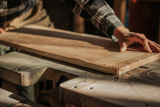 Crop artisan with wooden board in workshop