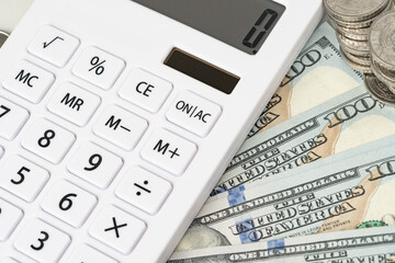 White calculator with American currency . A concept for recording income, expenses and controlling finances.