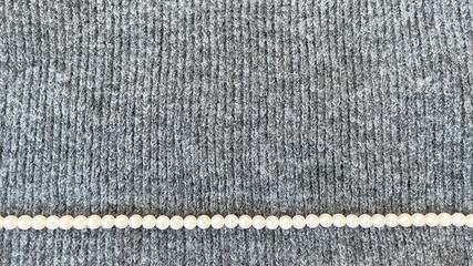 knitted wool texture and white pearl necklace