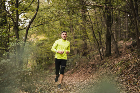 Active mature man jogging in forest