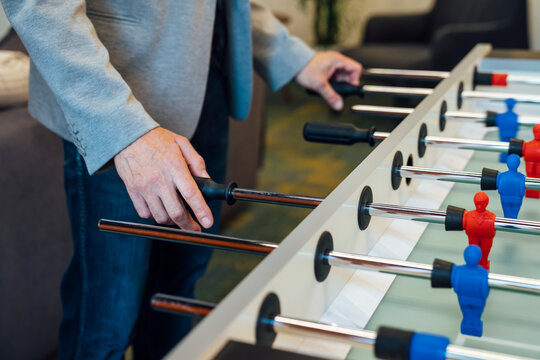 Hands of businessman playing foosball in office