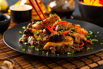 Traditional Korean Tteokbokki rice noodles with beef, vegetables and shitake mushrooms. Prepared in a wok.