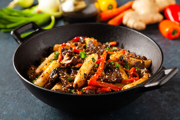 Traditional Korean Tteokbokki rice noodles with beef, vegetables and shitake mushrooms. Prepared in a wok.
