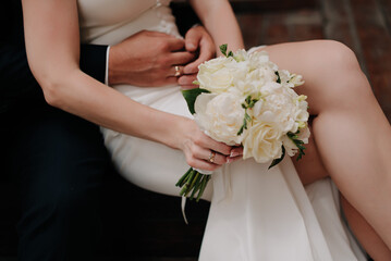 Wedding ring on bride's hand with wedding flowers