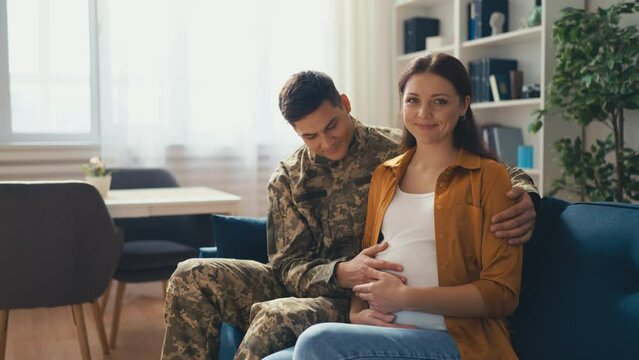 Portrait of young soldier and his wife expecting a baby, happy future parents