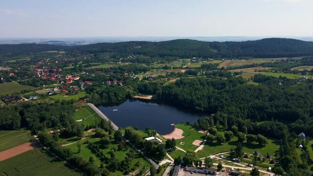 Aerial view of mountain village at summer day. Recreation area near Sleza Mountain with large lake and camping place. Summer outdoor recreation. Beautiful landscape of nature