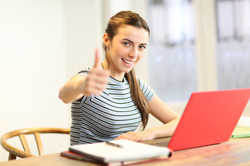 Happy student gesturing thumbs up at home