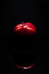red apple on black background with reflection