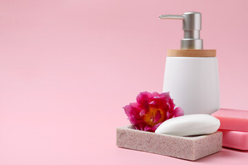 Obraz na płótnie Canvas Soap bar and bottle dispenser on pink background, space for text
