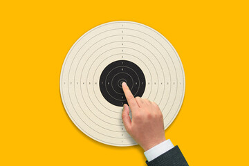 Target business concept with hand on yellow background
