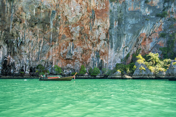 Traditional thai boat with tourists in the sea near tropical island, Thailand. Thai scenic exotic landscape of tourist destination famous place.