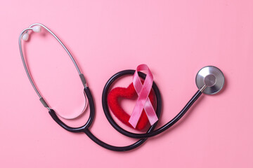 Pink ribbon breast cancer, heart shape and stethoscope on pink background with copy space.  Breast Cancer Awareness. 
