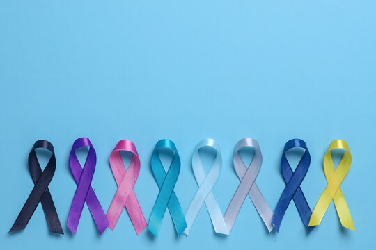 World cancer day arrange in line on blue background with copy space. Colorful awareness ribbons for supporting people living and illness. 