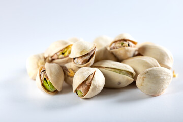 Pile of salted pistachios on white