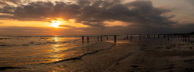 sunset over the sea of Bali Indonesia with crowded people