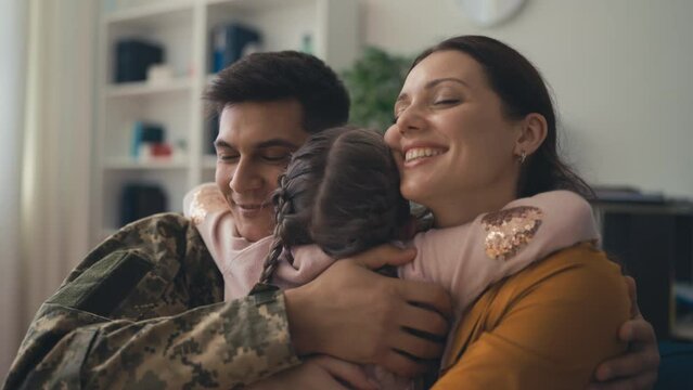 Cute girl hugging her parents, military man feeling happy with wife and daughter