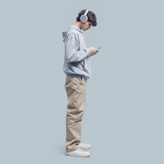 Teenager standing and using a smartphone
