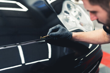 Professional car touch up done by expert on black luxurious car. Vehicle detailing. High quality photo