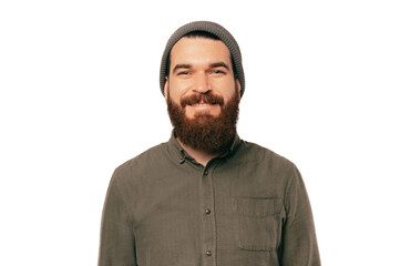 Portrait of young bearded smiling man looking confident at the camera over white backgorund wearing hat.