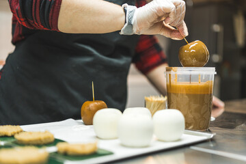 Unrecognizable person decorating pastry and pouring apples in caramel or chocolate sauce. Blurred background. High quality photo