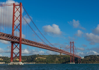 The "25 de Abril" suspension bridge (which translates to the "25th of April" Bridge) and the 'Cristo Rei' (which translates to "Christ the King") 
statue on the banks of the Tagus River in the capital