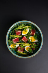 Salad with tuna grilled fillet, avocado and eggs. Top view. Copy Space