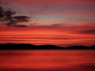 Sunset in the evening at a reservoir behind a dam.