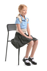 Fototapeta premium Little schoolgirl in back brace sitting on white background