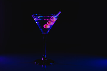 Drink martini. Martini with olives on a black table. Free space for text.