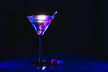 Drink martini. Martini with olives on a black table. Free space for text.