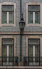 The old, metal, street lamps mounted on colorful tiled buildings in Lisbon, Portugal
