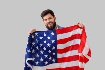 Handsome bearded man with USA flag on grey background