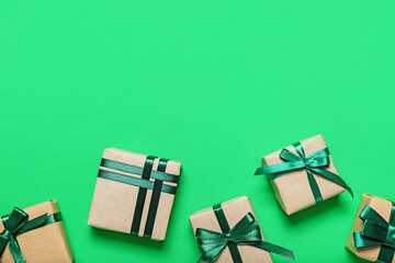Different gift boxes tied with green ribbon on color background