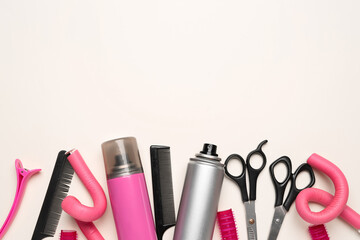 Hair sprays with curlers, scissors and combs on beige background